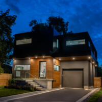 Modern Home, with dark and wood panels, offside view at night
