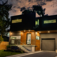 Modern Home, with dark and wood panels, offside view at night