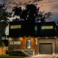 Modern Home, with dark and wood panels, offside view at night