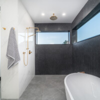 Modern dark bathroom with open shower and clawfoot bathtub
